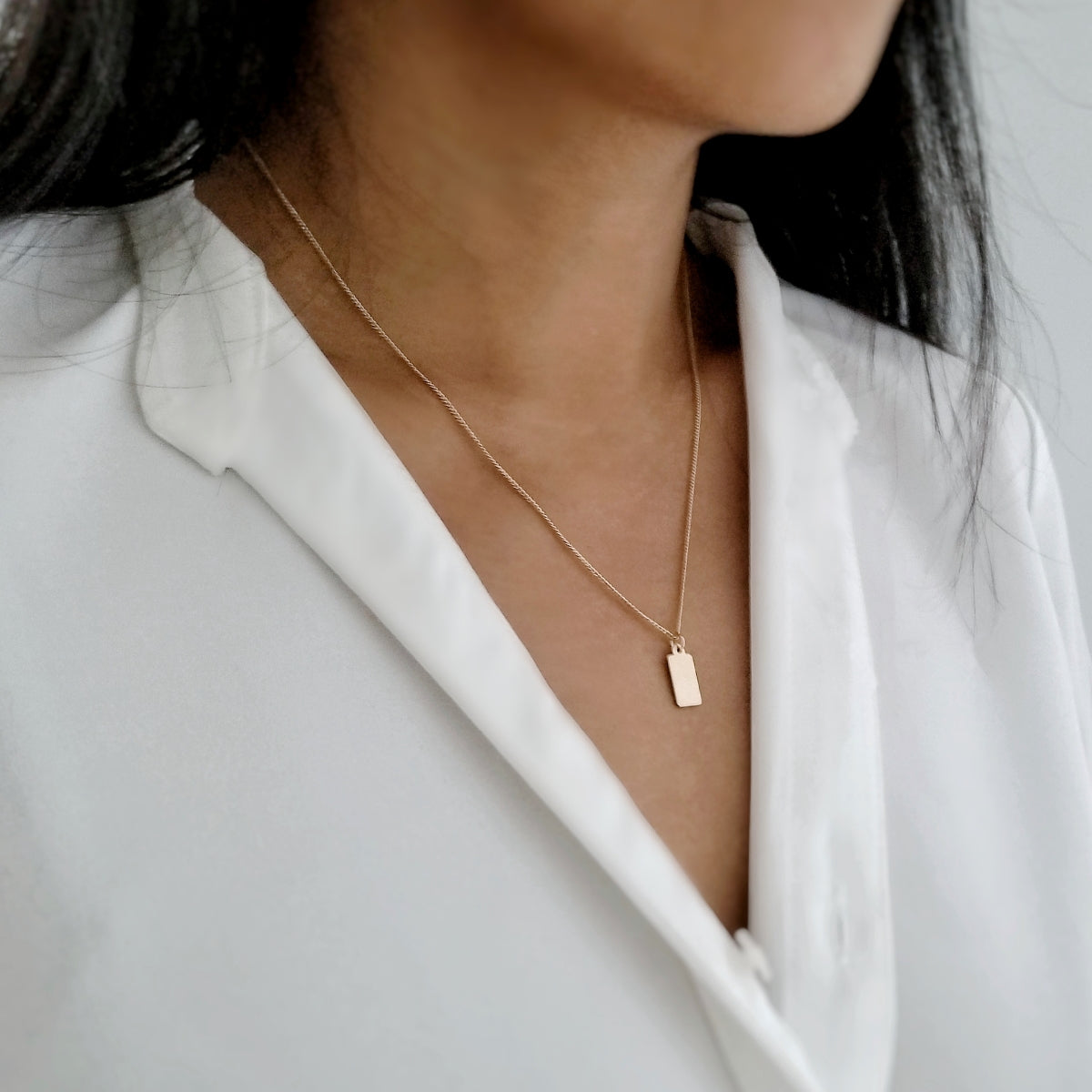 Gold necklace with blank initial tag