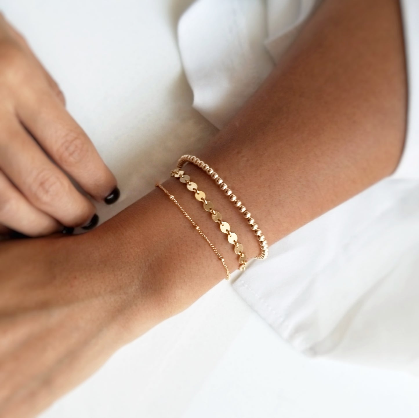 gold bracelet stack featuring the gold beaded bracelet layered with the gold coined and the gold satellite bracelet