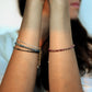 model wearing moonstone , aquamarine, amazonite, sapphire, onyx, ruby, garnet morse code bracelets
