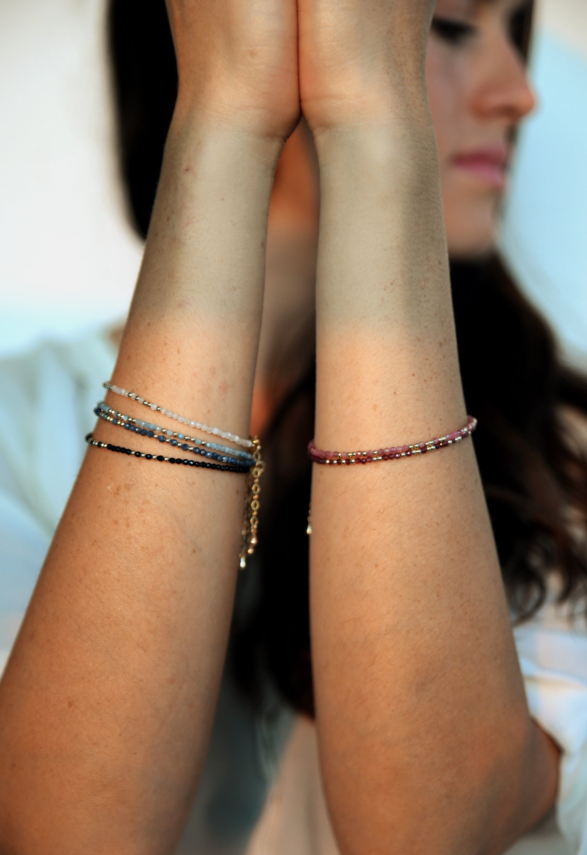 model wearing moonstone , aquamarine, amazonite, sapphire, onyx, ruby, garnet morse code bracelets